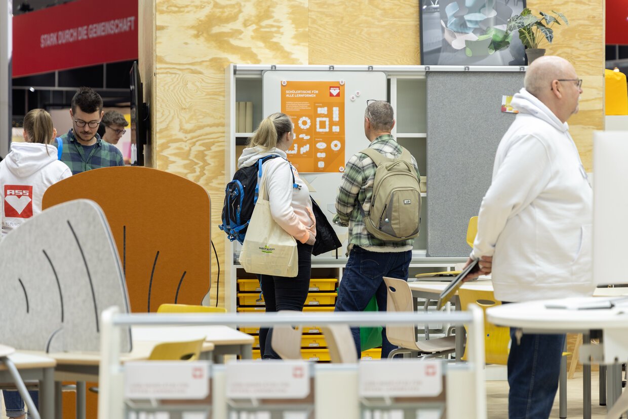 Besucher der Didacta erkunden den Stand von ASS Einrichtungssysteme