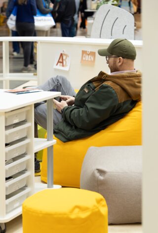 Ein Besucher der Didacta sitzt auf dem Stand von ASS Einrichtungssysteme in einem Sitzsack
