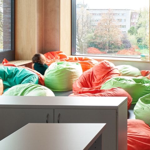 Helle Raumecke mit bunten Sitzsäcken und zwei Kindern