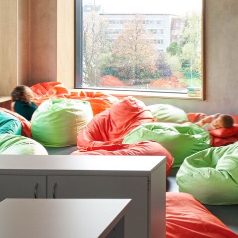 Helle Raumecke mit bunten Sitzsäcken und zwei Kindern