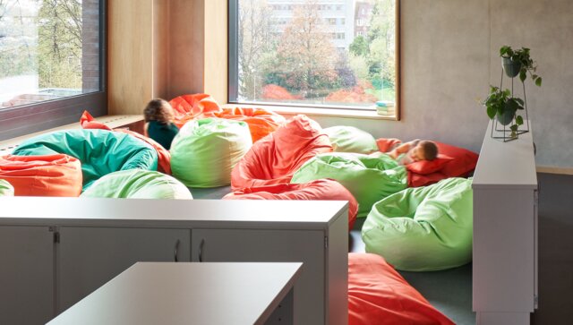 Helle Raumecke mit bunten Sitzsäcken und zwei Kindern