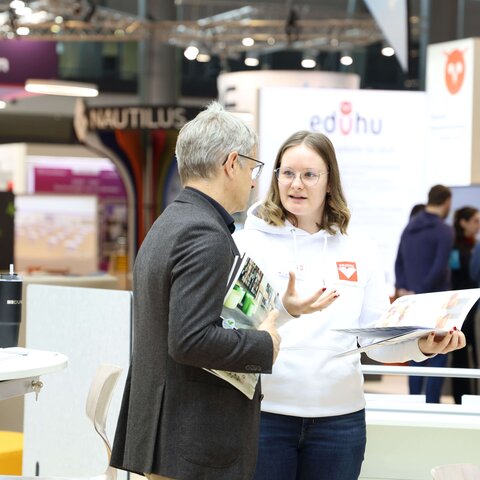 Beratungsgespräch zwischen zwei Personen auf einer Messe