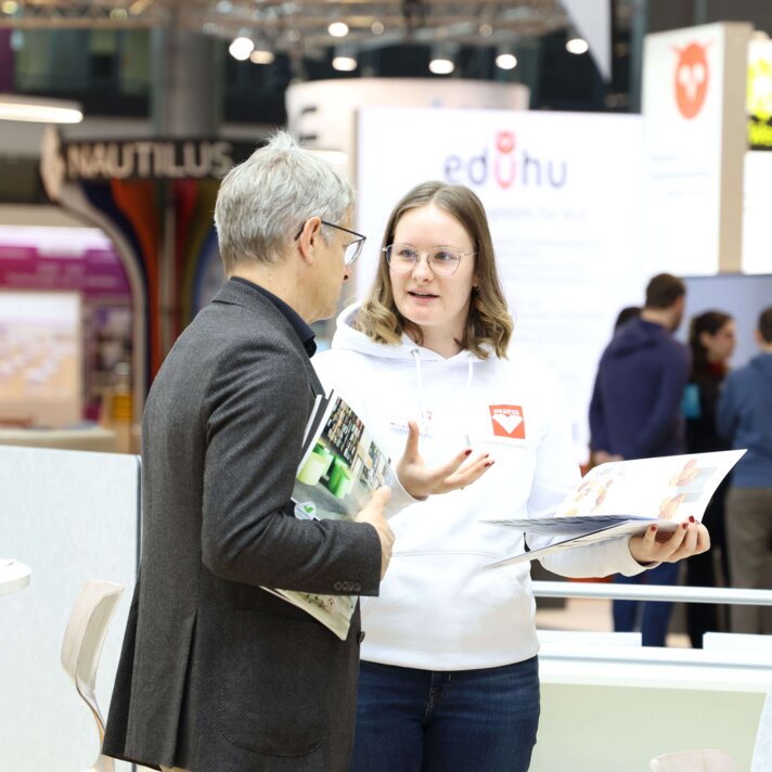 schulbau_beratungsgespraech Beratungsgespräch zwischen zwei Personen auf einer Messe